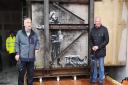 Art dealer John Brandler (left), with garage owner Ian Lewis, with Banksy's Season's Greetings prior to its removal to an art gallery.