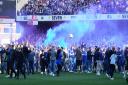 Ipswich Town fans celebrate on the pitch after their side won promotion to the Championship