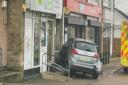 A dog has died after being hit by a car that crashed into a shop front