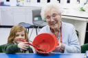 Mildenhall Lodge resident Sylvia Lovell mixing ingredients with Sophia during a baking session with Great Heath Primary Academy, Mildenhall.