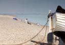 Visitors enjoying a sunny day at Dunwich beach on the Suffolk coast