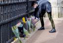 A member of the public leaves flowers outside Buckingham Palace, London, following the announcement of the death of the Duke of Edinburgh at the age of 99.