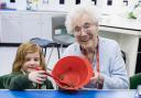 Mildenhall Lodge resident Sylvia Lovell mixing ingredients with Sophia during a baking session with Great Heath Primary Academy, Mildenhall.