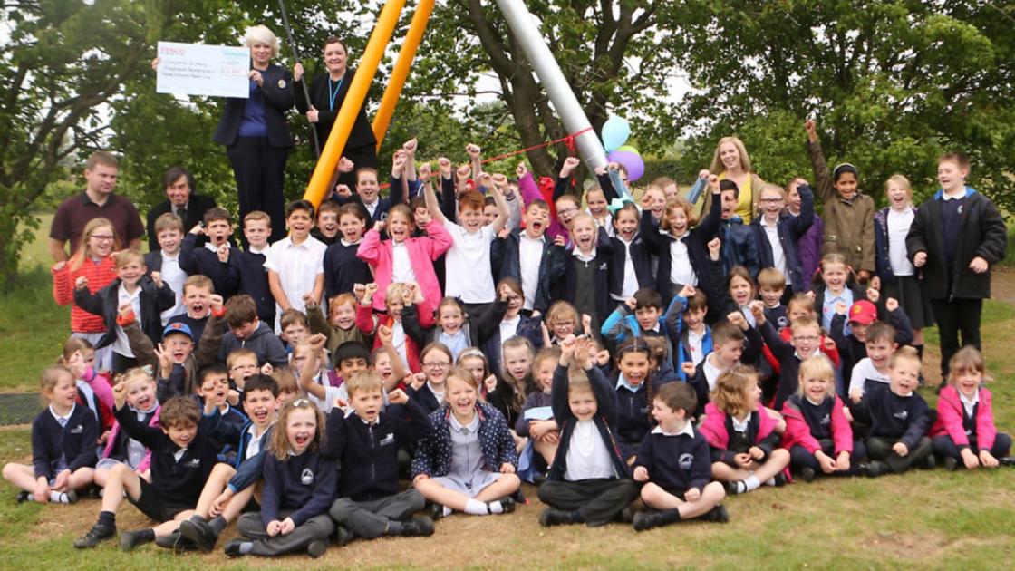 Headteacher at Stratford St Mary Primary School has first go on village's new playground zip wire 