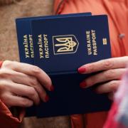A woman holds Ukrainian passports as she waits to register in Poland.
