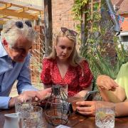 Ukrainian refugees Olena and Iryna using a phone translator with South Suffolk MP James Cartlidge.