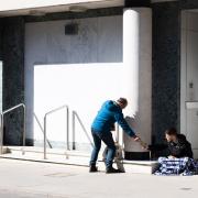 A passer by shares his food with a homeless man. Picture: SARAH LUCY BROWN