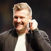 Oxford United manager Karl Robinson reacts to banter from Town fans as he walks of at half-time.