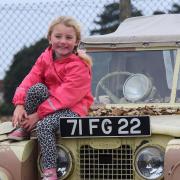 Four-year-old Ruby Reed, with a 1951 Land Rover in desert camouflage, at the Suffolk Aviation Heritage Museum fundraising day in Kesgrave.
