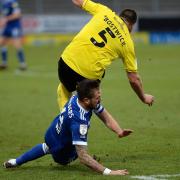 Luke Chambers slides underneath Michael Bostwick at Burton Albion and gets booked for it. Picture Pagepix Ltd
