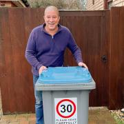Suffolk county councillor Stuart Lawson, who represents Kesgrave and Rushmere St Andrew, with a wheelie bin bearing one of the stickers warning motorists about the speed limit.