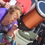 A Suffolk astronomer has had an asteroid named after her.  An image of a member of the public exploring astronomy.