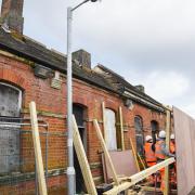 Workmen erect the hoardings to protect station staff and passers-by at Trimley station