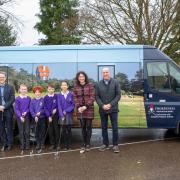 Christine Langford, far left, director of golf at Thorpeness Golf Club, with the new minibus, pupils and staff at Leiston Primary School and Andy Crisp, from car dealership Victory Car Sales, which supplied the minibus