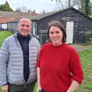 Richard Lister and Jenny Cousins at the Food Museum beside the huts they hope to move to a new site.