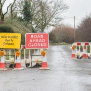 Road closure signs remain in place on the road